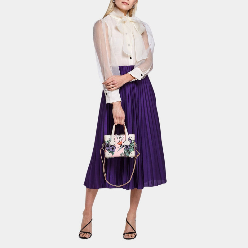 Model with the mini Botanist fibreboard suitcase in pink with shoulder attachment strap