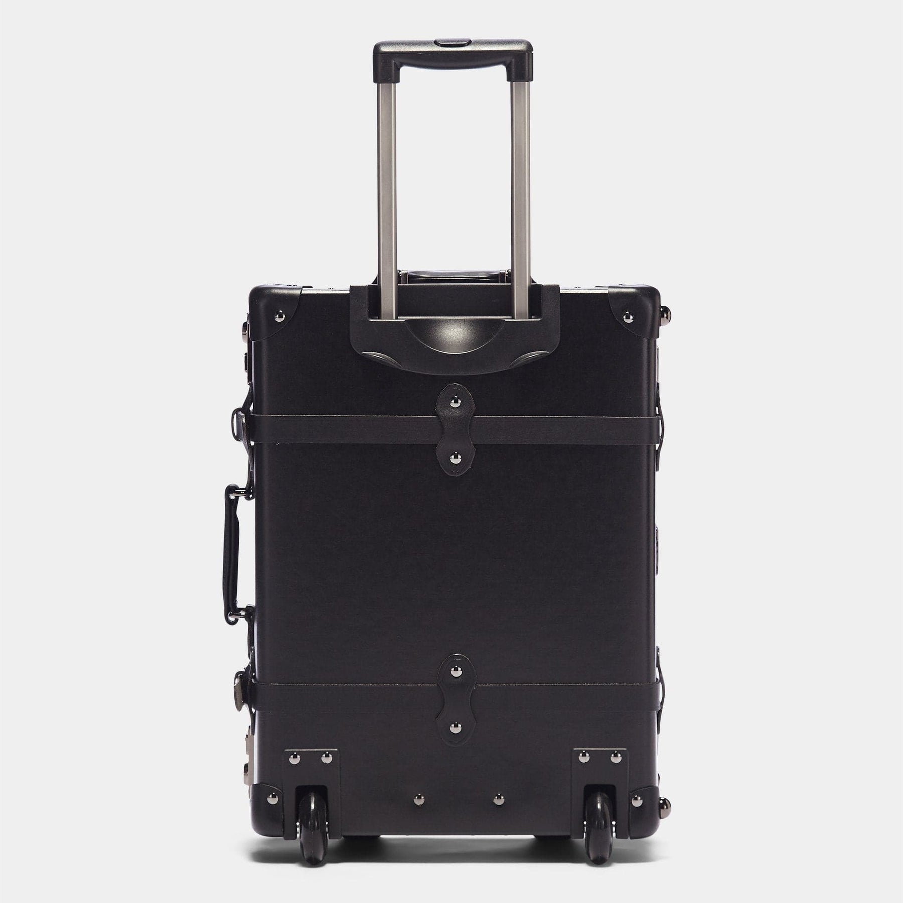 Back product view of the carry-on Industrialist fibreboard suitcase in black with raised handle