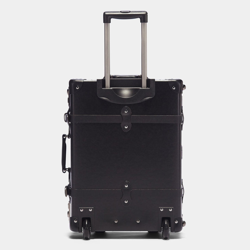 Back product view of the carry-on Industrialist fibreboard suitcase in black with raised handle