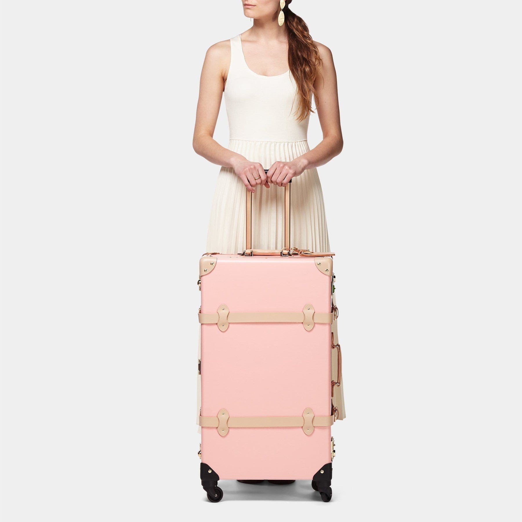 Model with the check-in Correspondent fibreboard suitcase in pink with raised handle