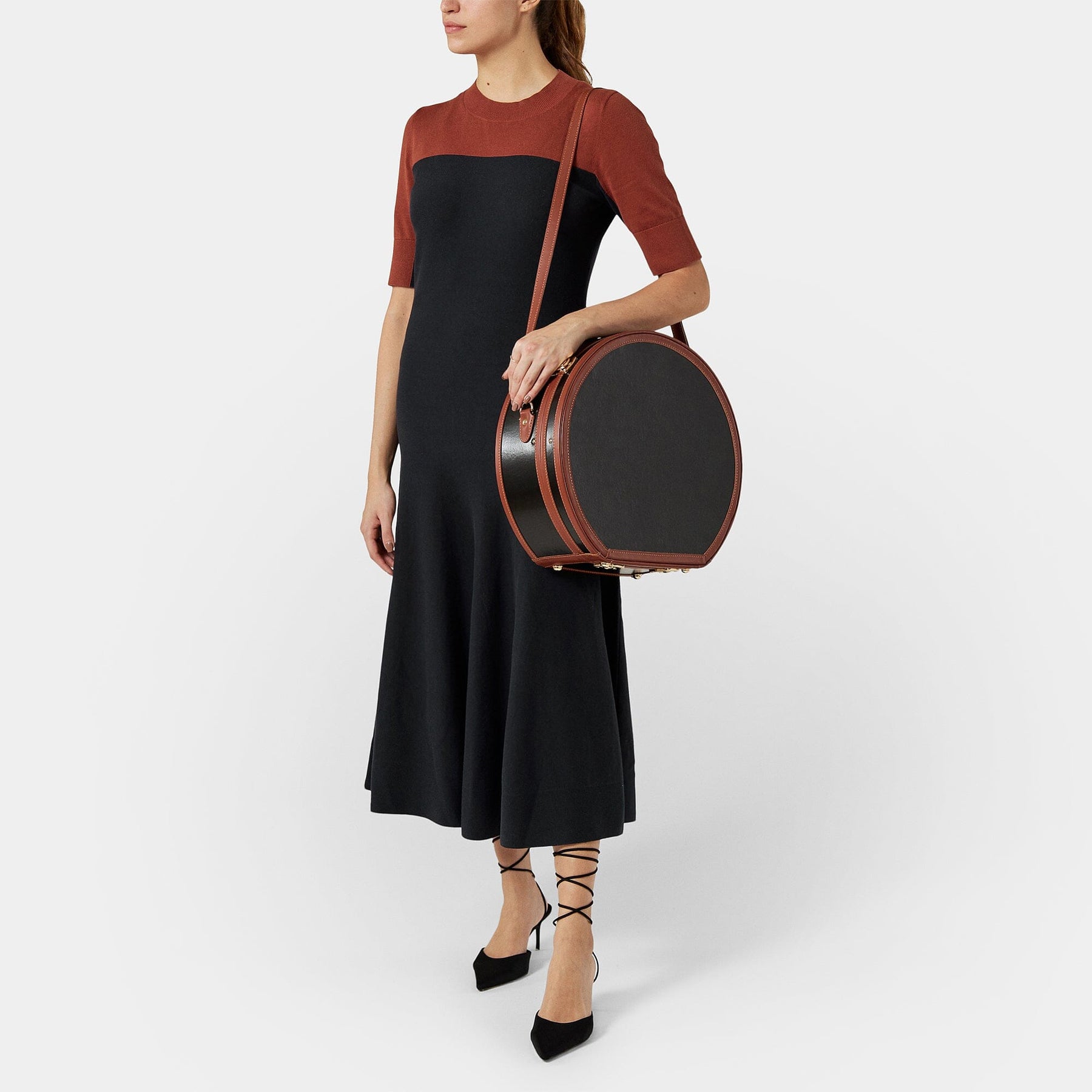 Model with the deluxe hatbox Diplomat leather suitcase in black with shoulder attachment strap