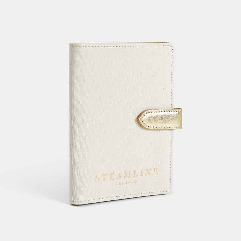 Angled view of the Navigator leather passport holder in white with gold trim and logo