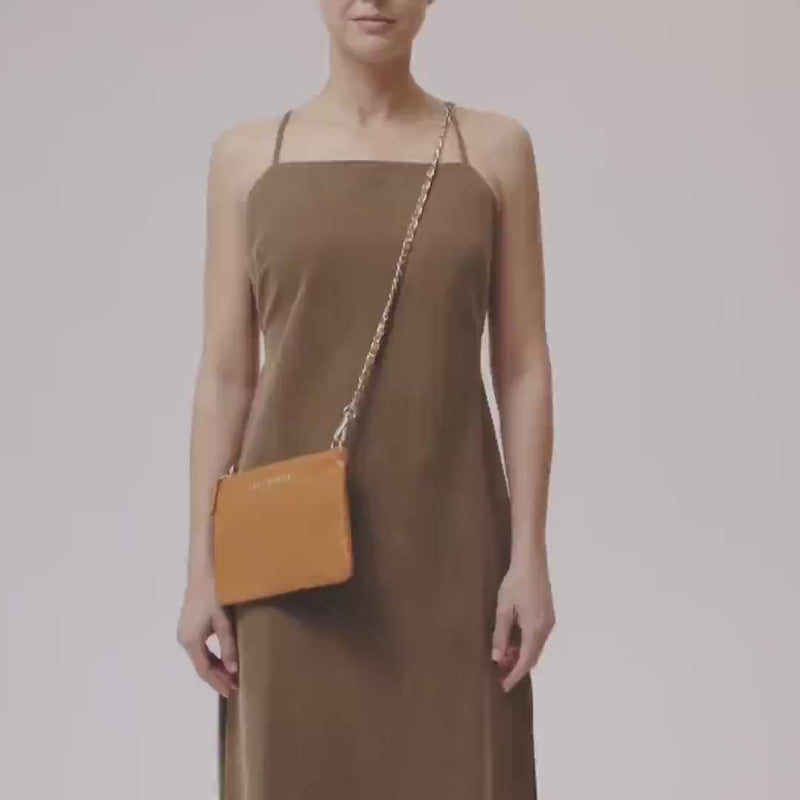 Video of model with the Navigator leather crossbody in nut with gold trims and detachable chain strap