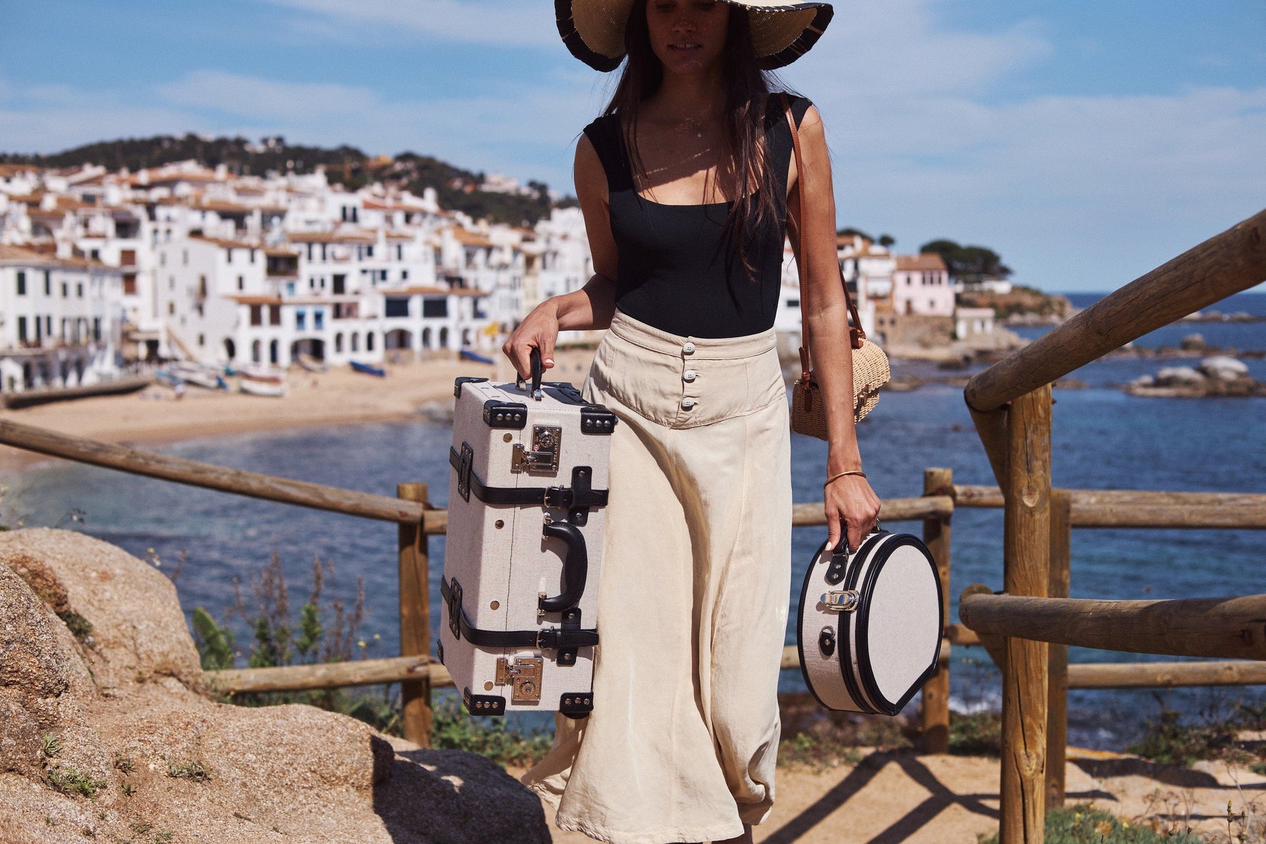 Lifestyle image of model with the Editor linen suitcases with black trims