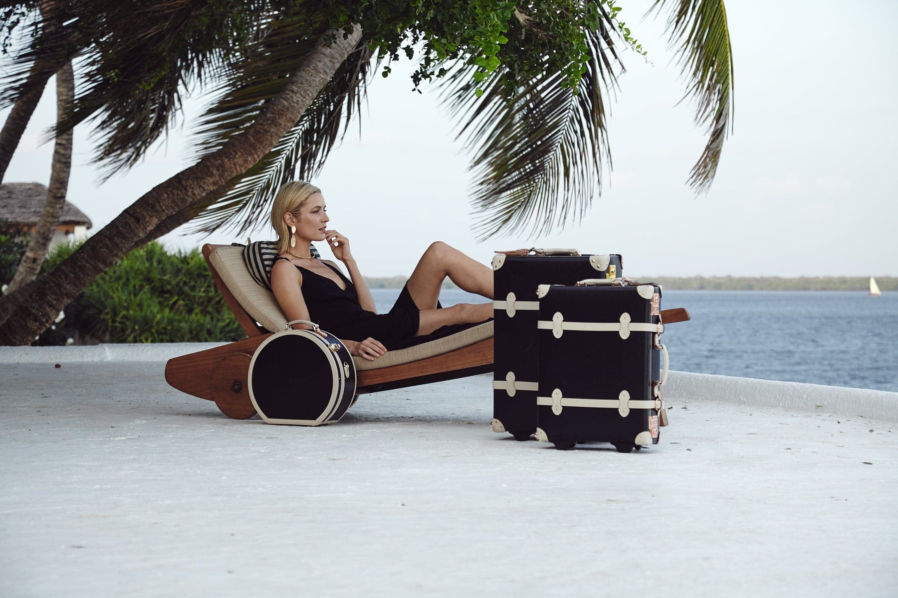 Lifestyle image of model with The Starlet fibreboard carry-on in black