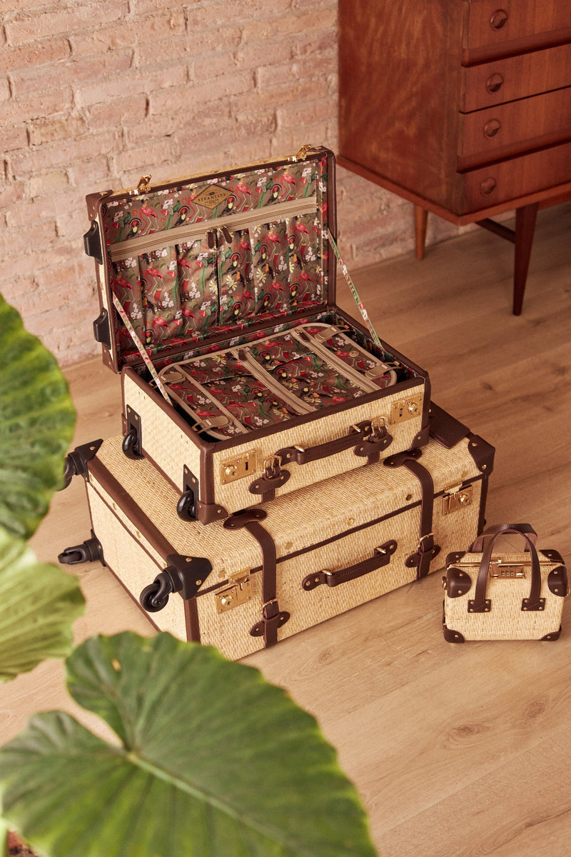 Lifestyle image of the Explorer rattan suitcases in natural wicker body and brown trims