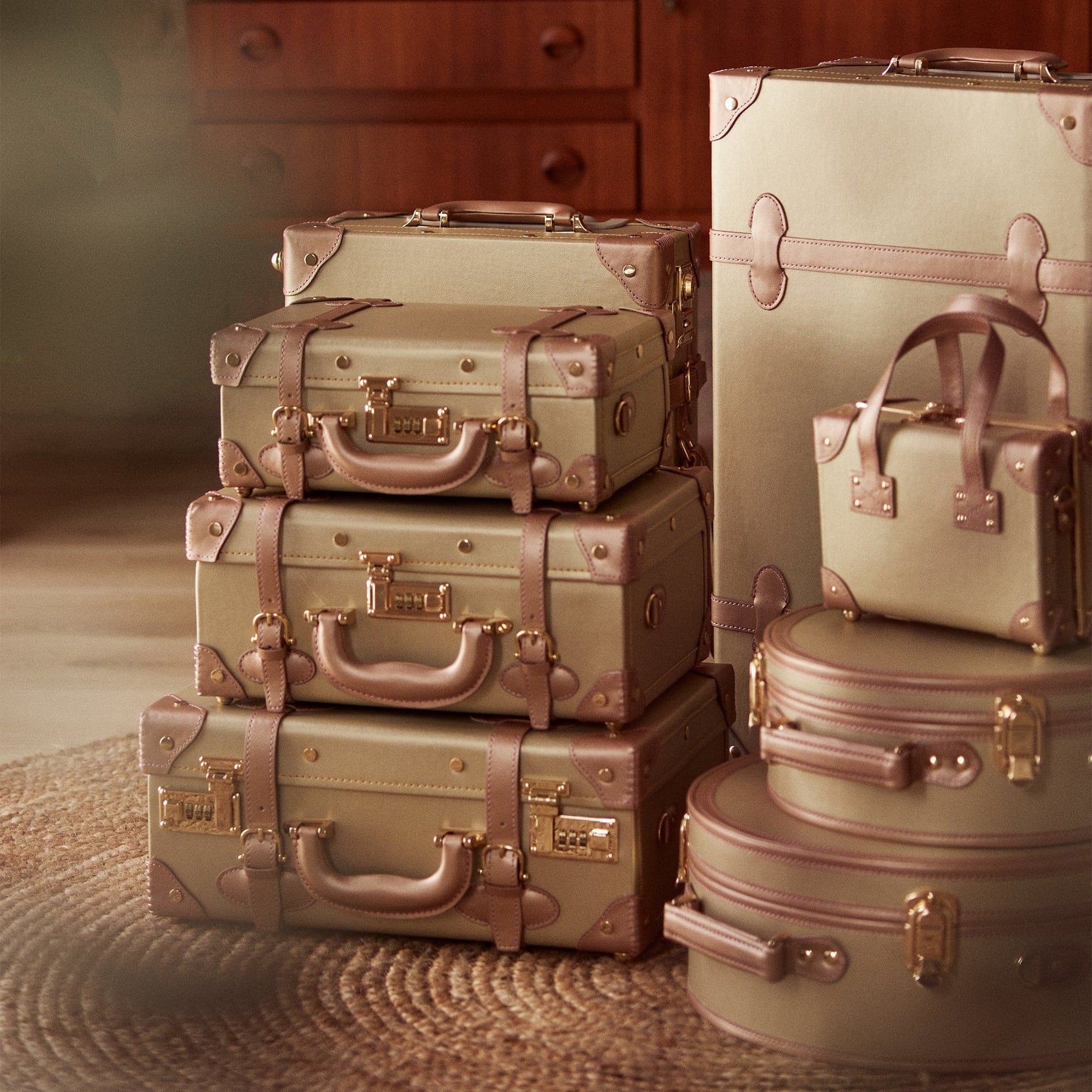 Lifestyle image of The Alchemist vegan leather suitcases in gold 