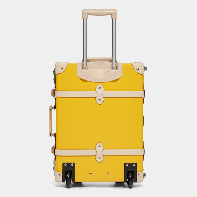 Back product view of the carry-on Correspondent fibreboard suitcase in canary yellow with raised handle