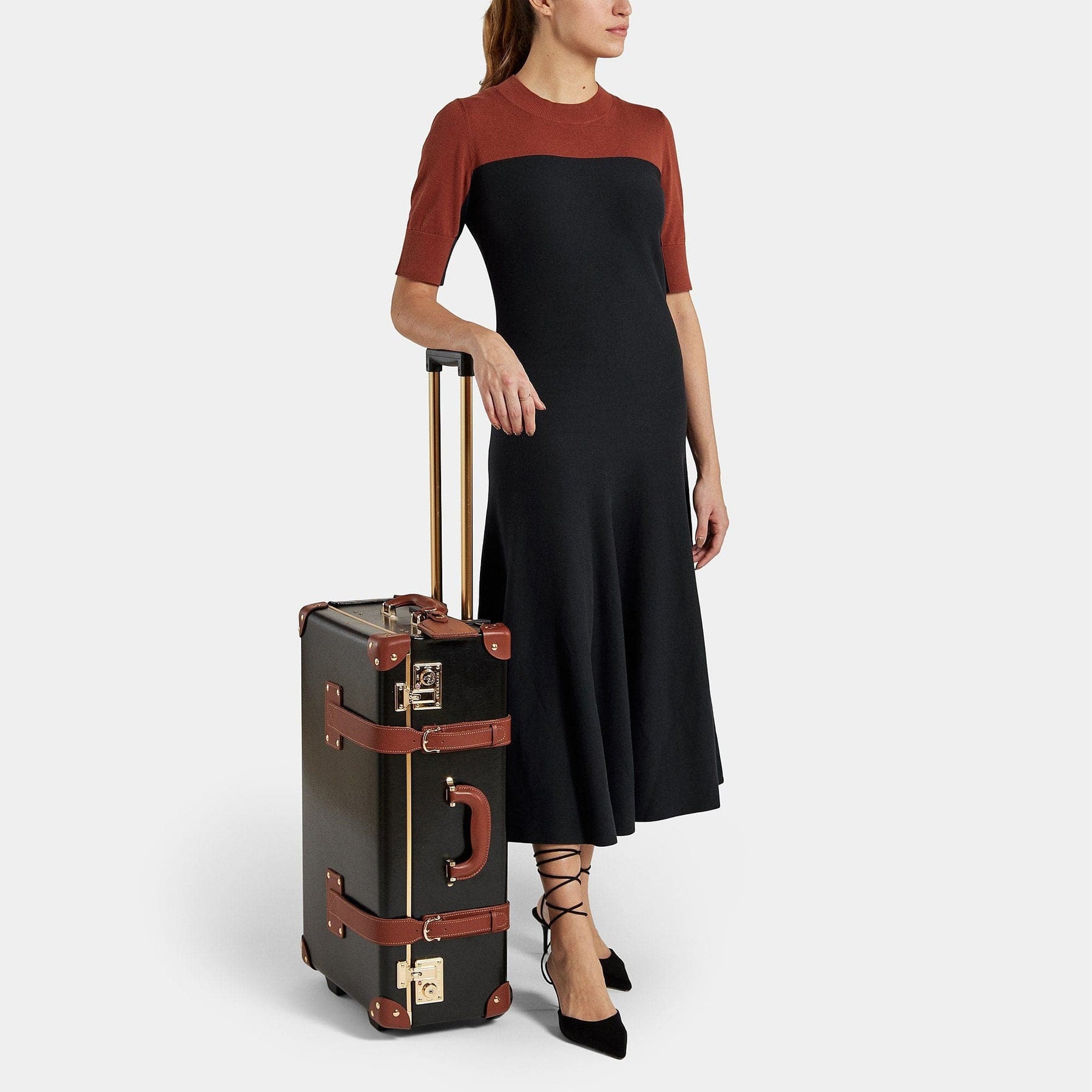 Model with the stowaway Diplomat leather suitcase in black with raised handle