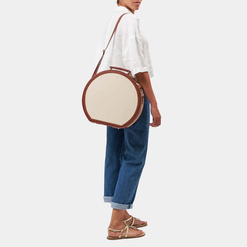 Model with the large hatbox Diplomat leather suitcase in cream with shoulder attachment strap