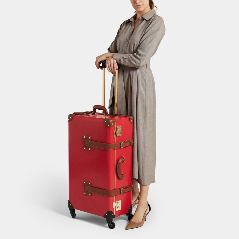 Model with the check-in Diplomat leather suitcase in red with raised handle