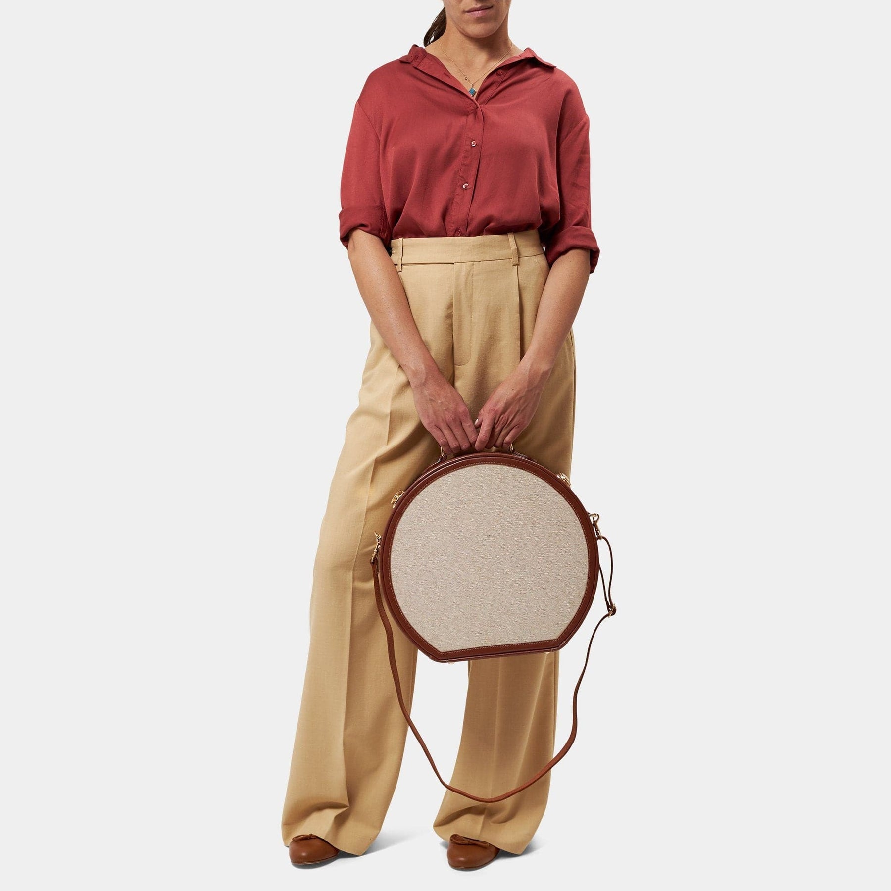 Model with the large hatbox Editor linen suitcase with brown trims and shoulder attachment strap