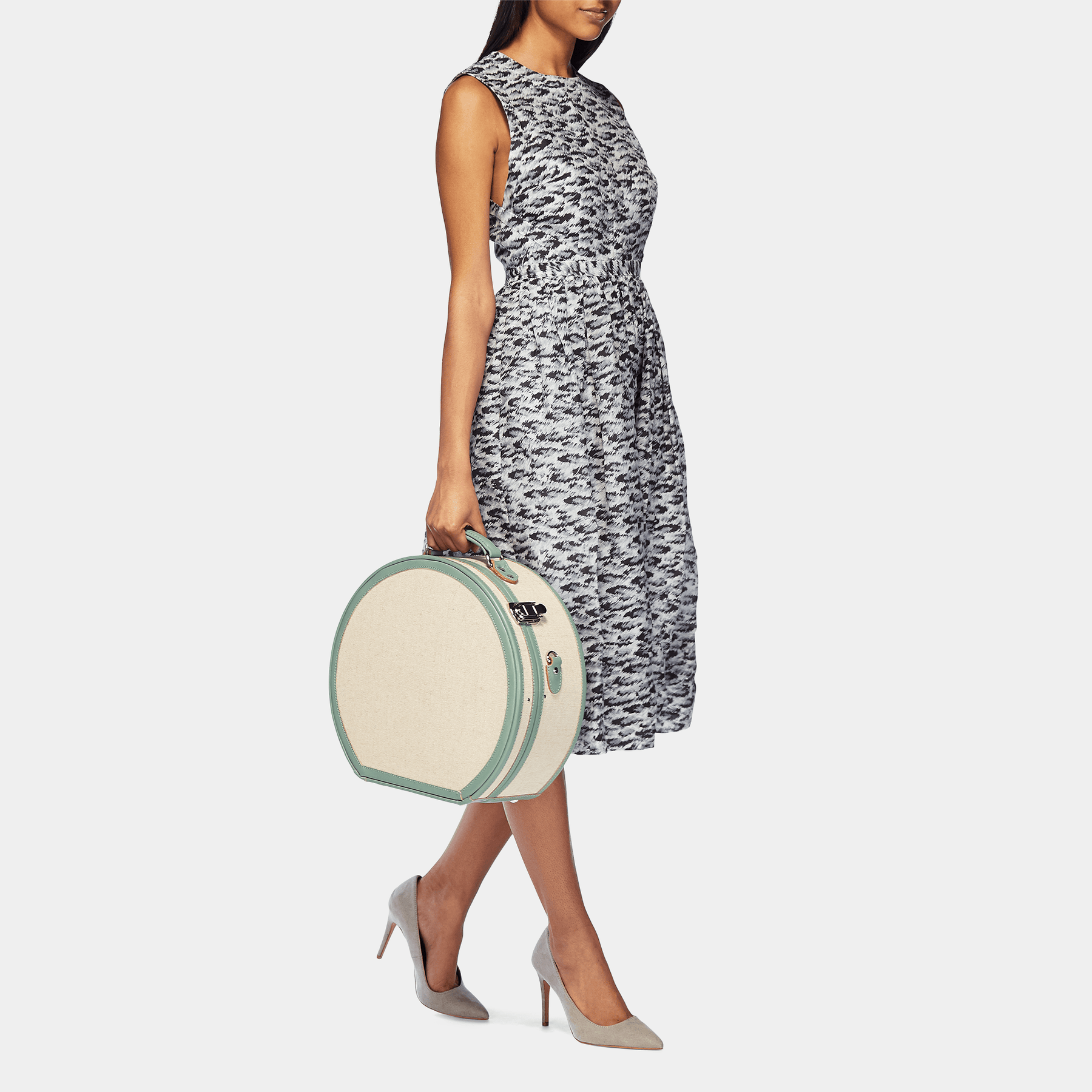 Model with the large hatbox Editor linen suitcase with sea green trims