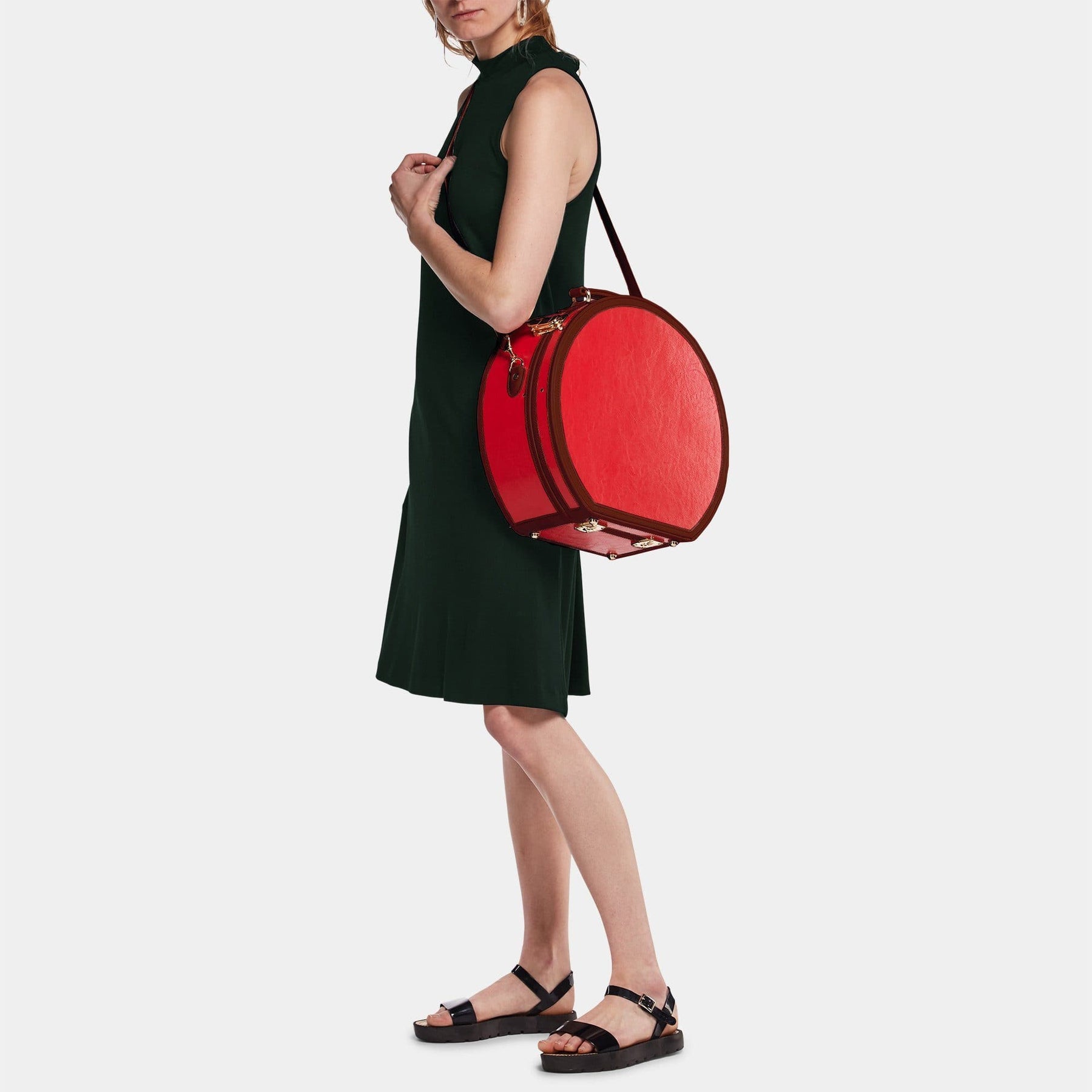 Model with the large hatbox Entrepreneur vegan leather suitcase in red with shoulder attachment strap