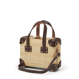 Angled product view of the mini Explorer rattan suitcase in natural wicker body and brown trims with shoulder attachment strap