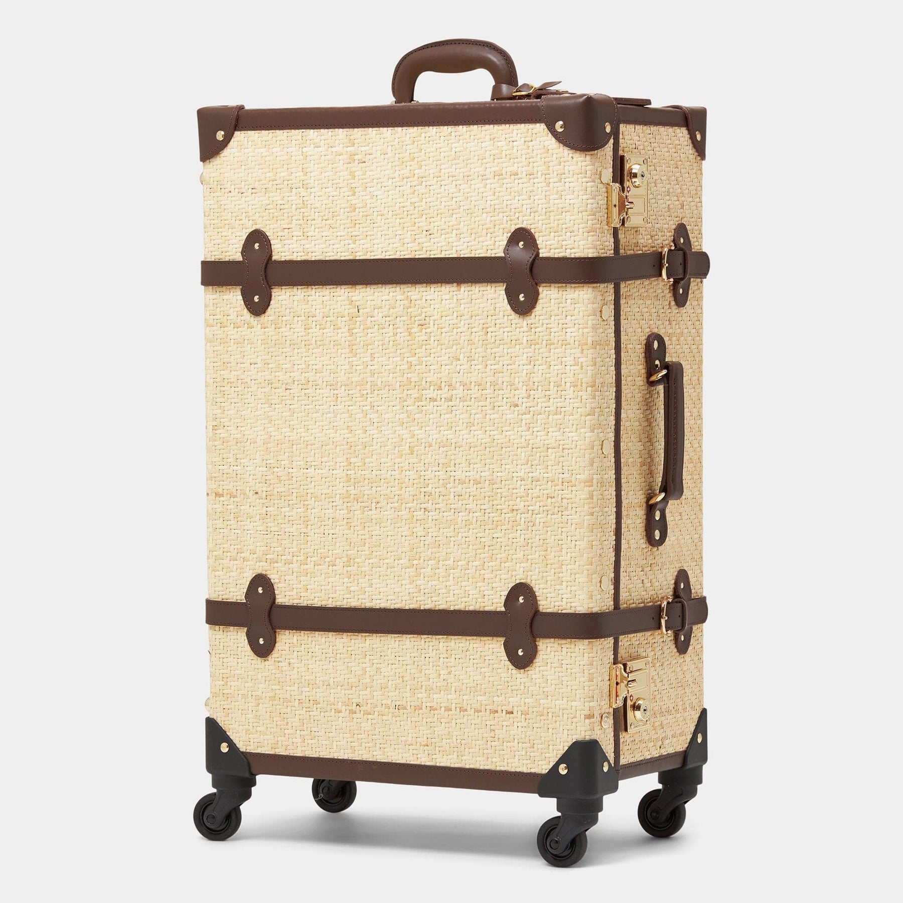 Angled product view of the check-in spinner Explorer rattan suitcase in natural wicker body and brown trims 