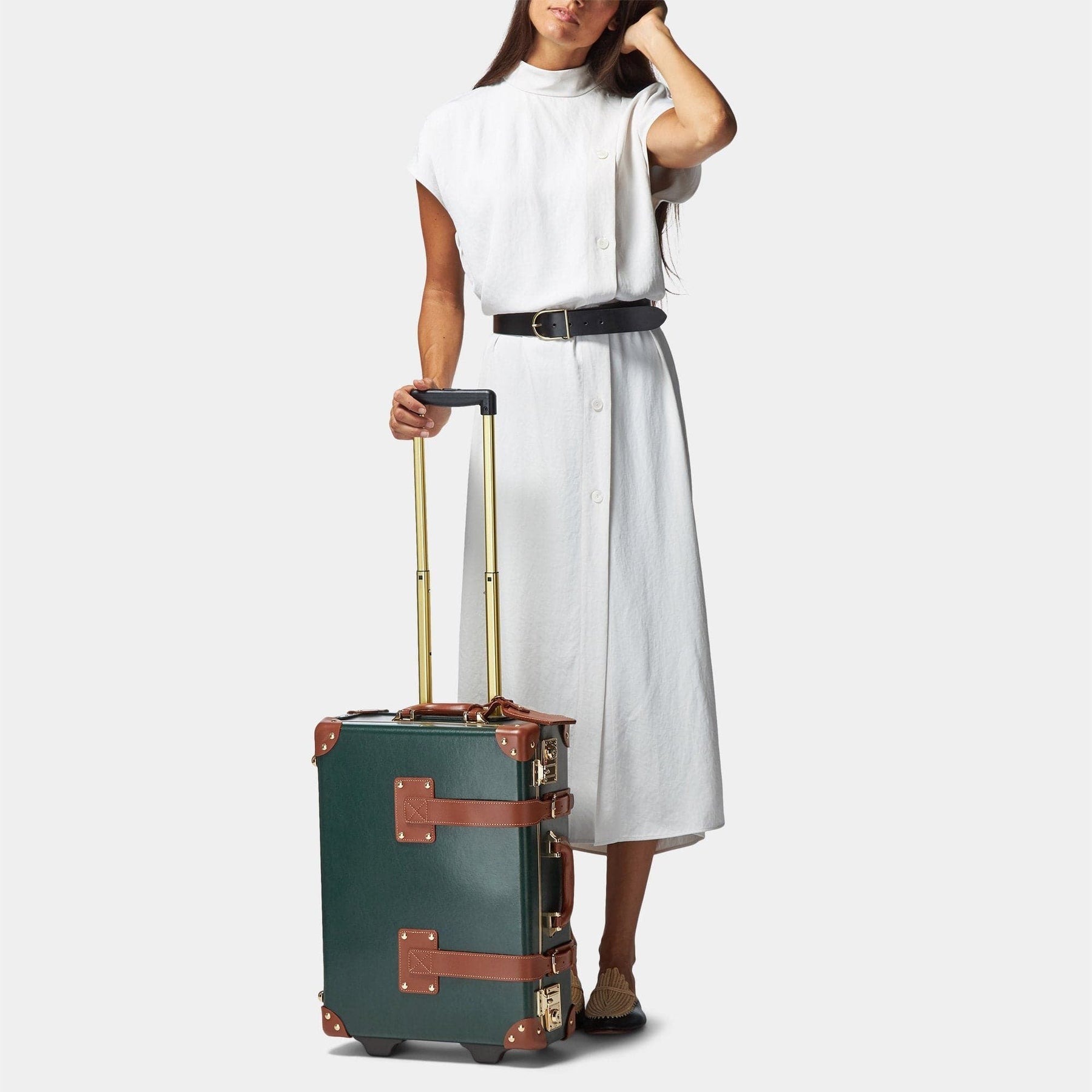 Model with the carry-on Diplomat leather suitcase in hunter green with raised handle