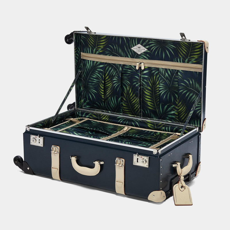 Open product view of the check-in Anthropologist leather suitcase in navy with green palms print  lining and cream leather luggage tag