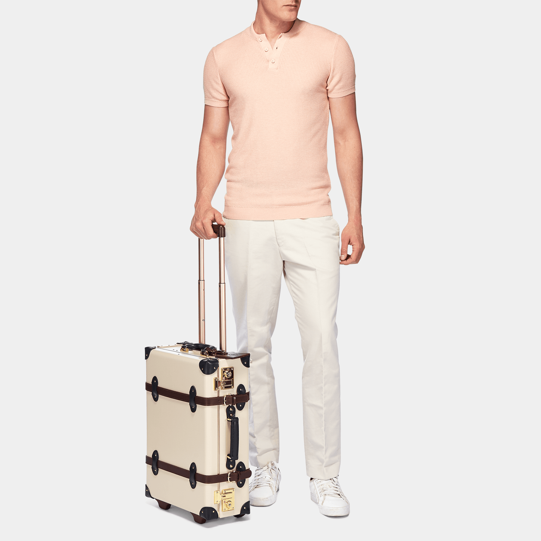 Male model with the carry-on Architect leather suitcase in cream with raised handle