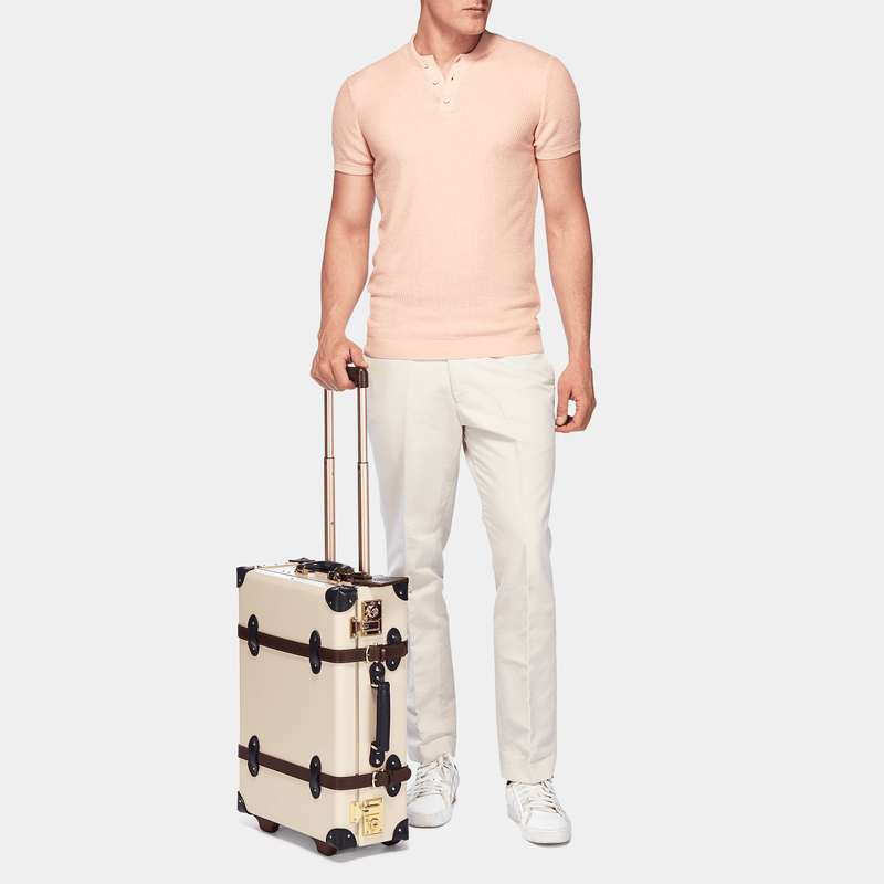 Male model with the carry-on Architect leather suitcase in cream with raised handle
